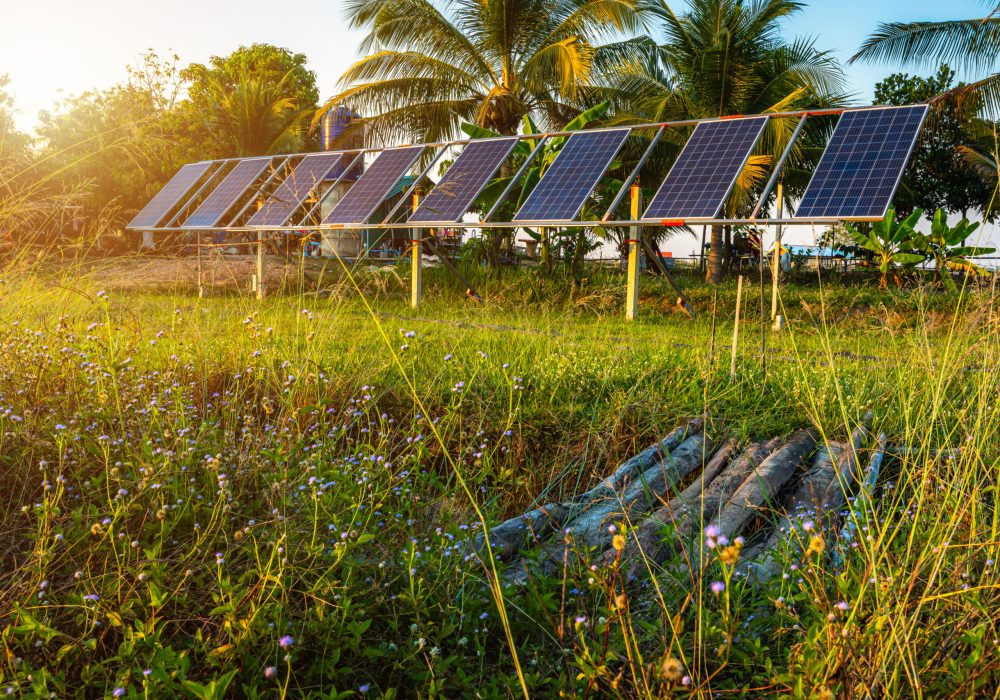 photovoltaic solar power panel for agriculture in a rural houses area Agricultural fields blue sky background,Agro-industry of household Rural style in Thailand, smart farm alternative clean energy.
